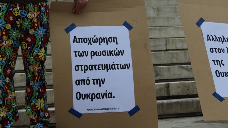 a couple of people standing next to each other holding signs