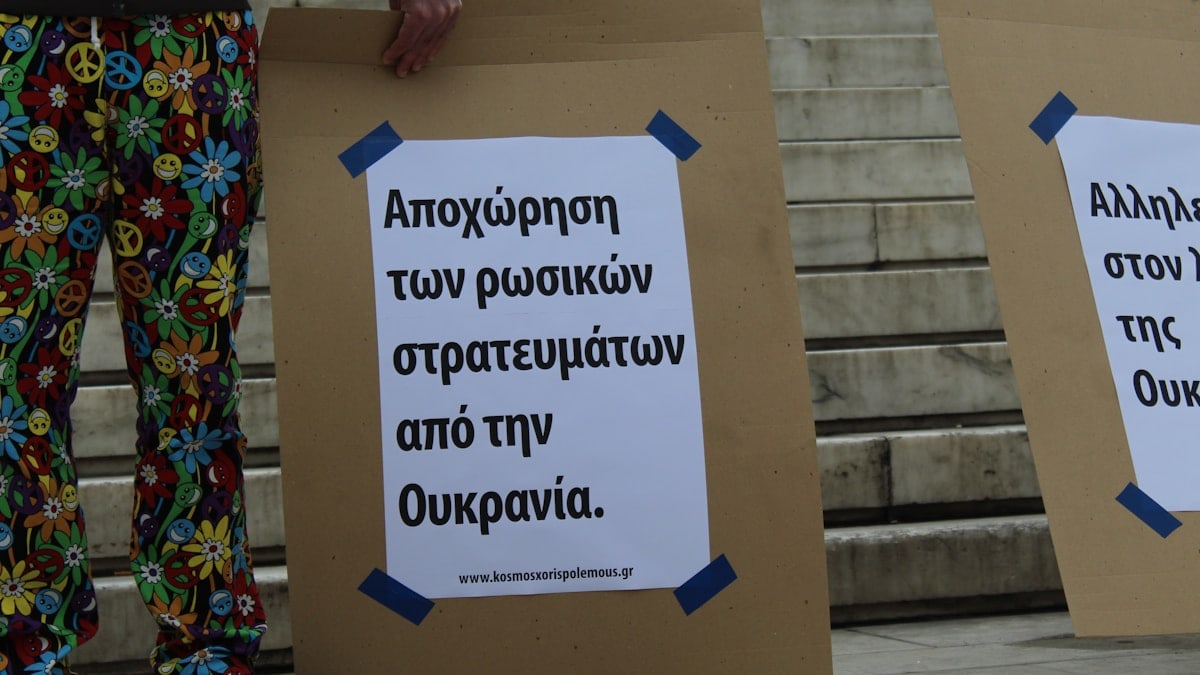 a couple of people standing next to each other holding signs